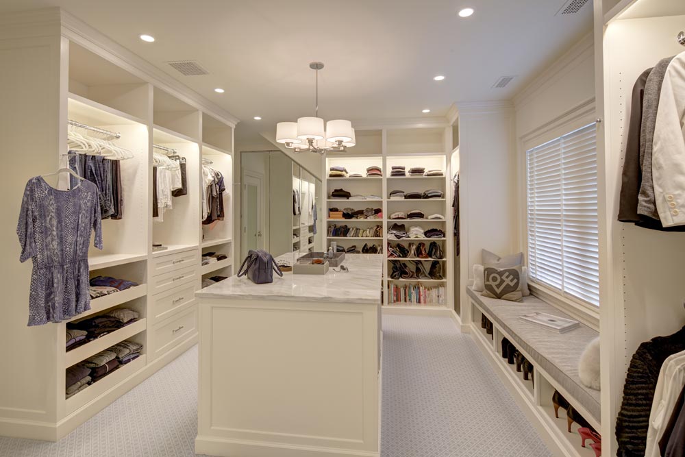 large 2-room closet painted white with open shelving and custom lighting